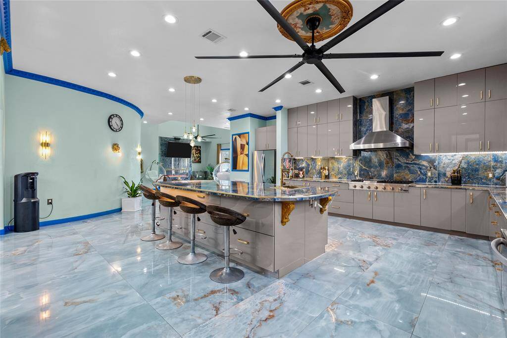 Open kitchen allows plenty of room for special guest, featuring porcelain floors and counters, and not shy on cabinet space.