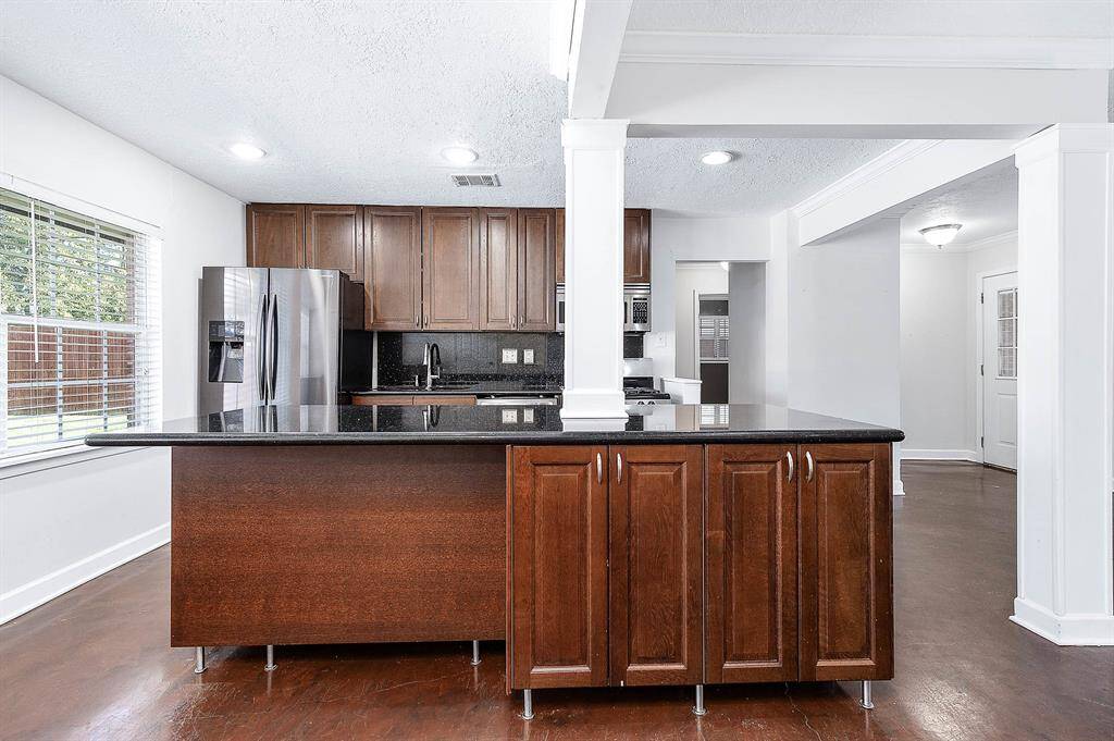 The Kitchen Has Large Granite Island And Plenty Of Cabinets For Storage.