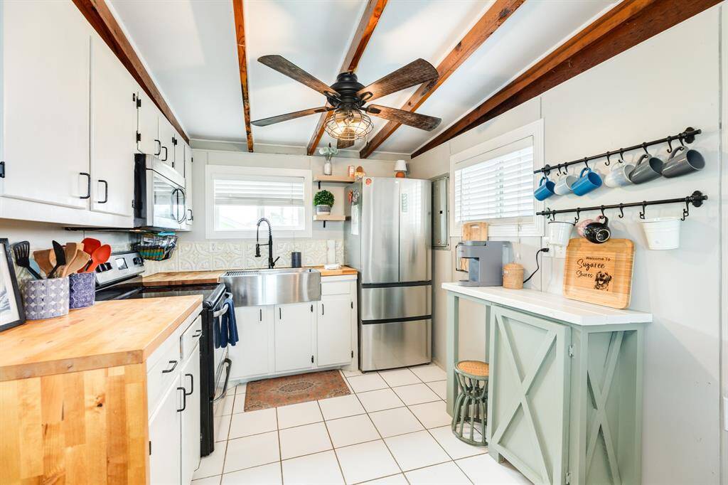 This kitchen utilizes all of it space so well.  The gleaming new farm sink and faucet give you an outside view.  New refrigerator and lots of storage make this kitchen the complete package.  The coffee bar gives more storage.
