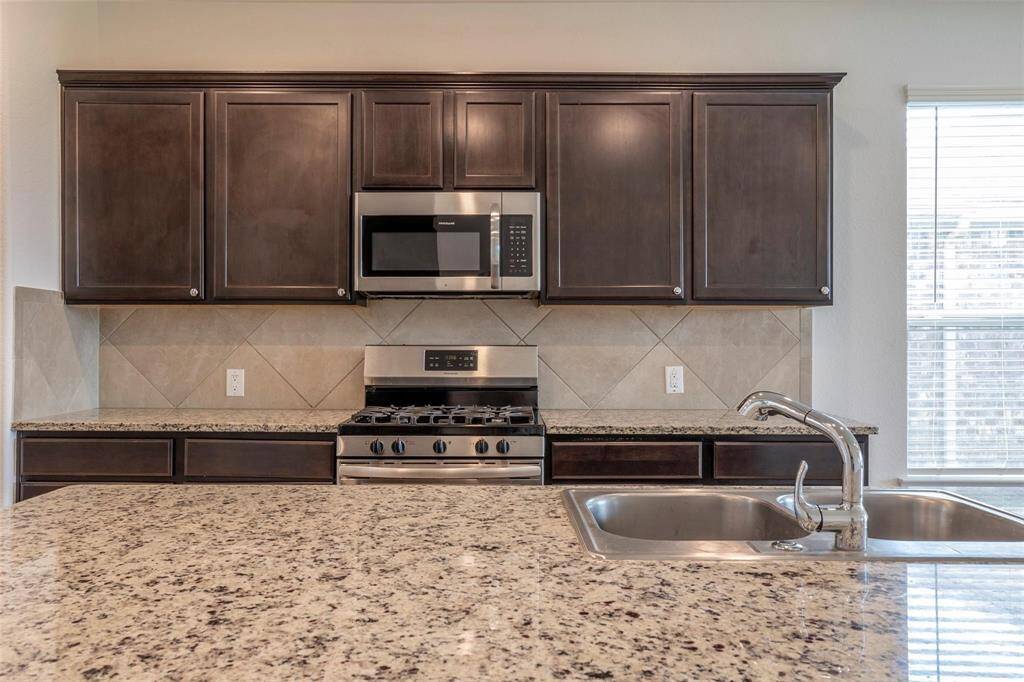 Stainless steel appliances and rich espresso cabinets.