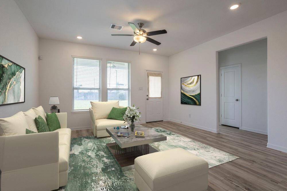 STAGED: Living room area with warm flooring close to the half bath for guests.