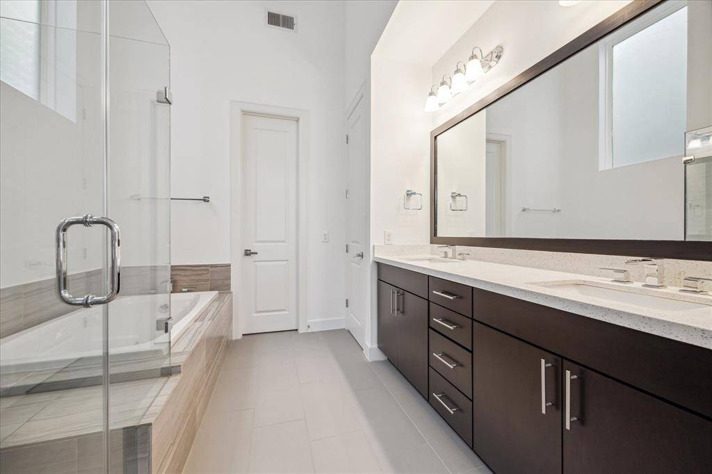 Primary bathroom with double sink vanity, soaking tub and separate shower and water closet.