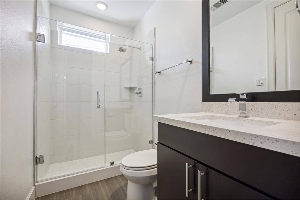 En-suite bathroom includes single sink vanity, shower only, and walk-in closet.