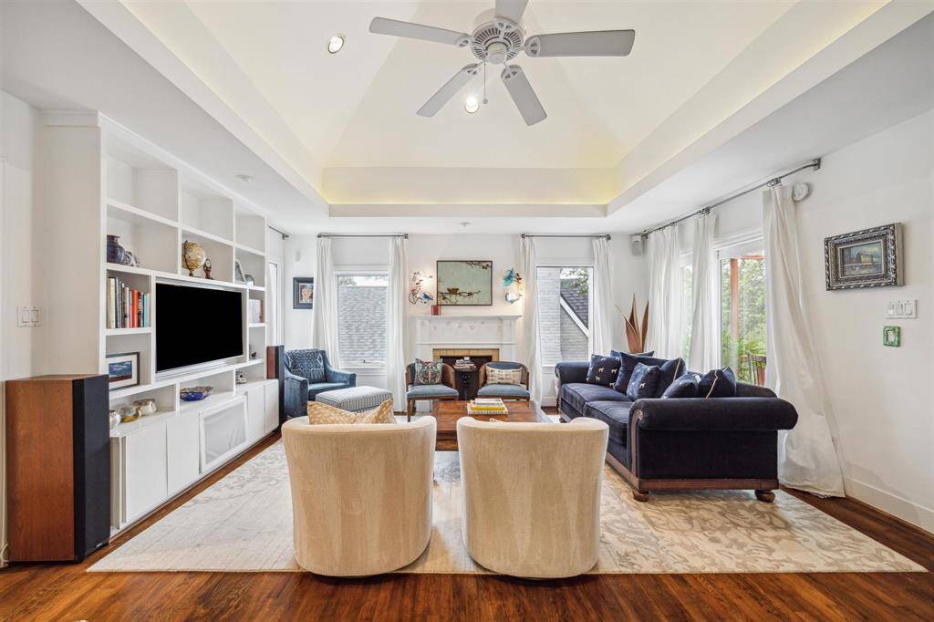 Living area featuring custom built-ins Entertainment system includes in-ceiling speakers in all rooms.  Note the custom iron sconces above hearth fashioned by the late Houston legendary welding artist, Gertrude Barnstone.