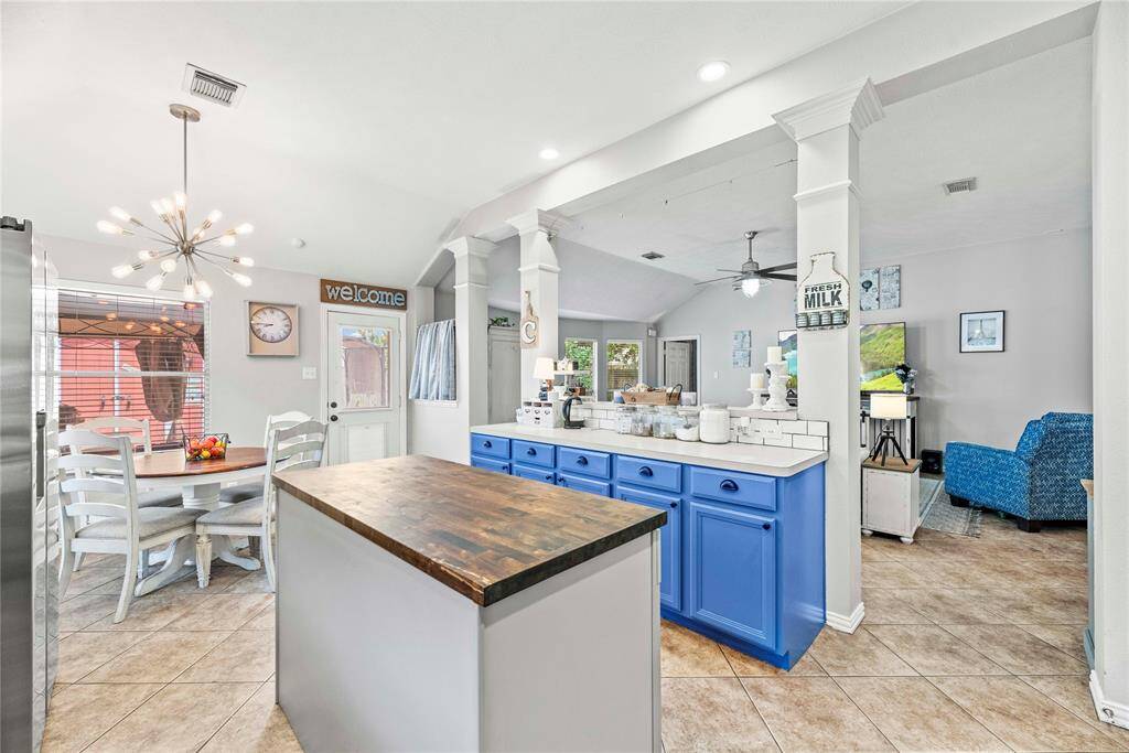 This beautifully appointed kitchen features a butcher block island and a separate serving bar that opens to the family room. Both features offer ample storage below and provide convenient spaces for serving guests drinks and snacks.