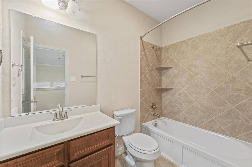 Clean and functional bathroom with a shower/tub combo and vanity.
