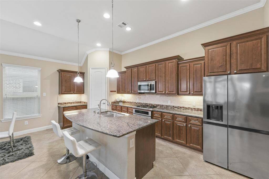 Modern kitchen with stainless steel appliances and granite countertops.