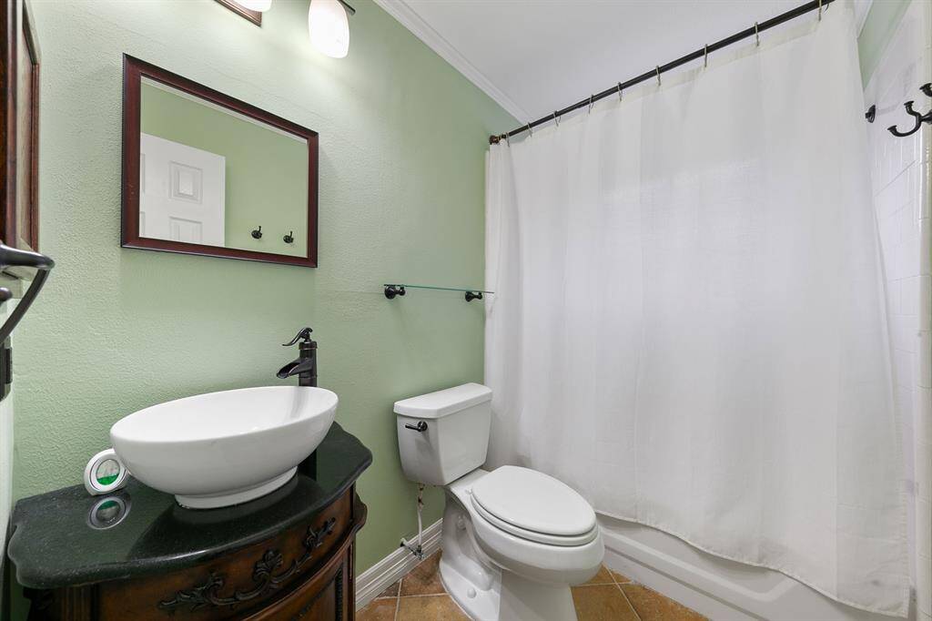 The secondary bathroom features a tub-shower combination with modern finishes, offering both style and convenience.