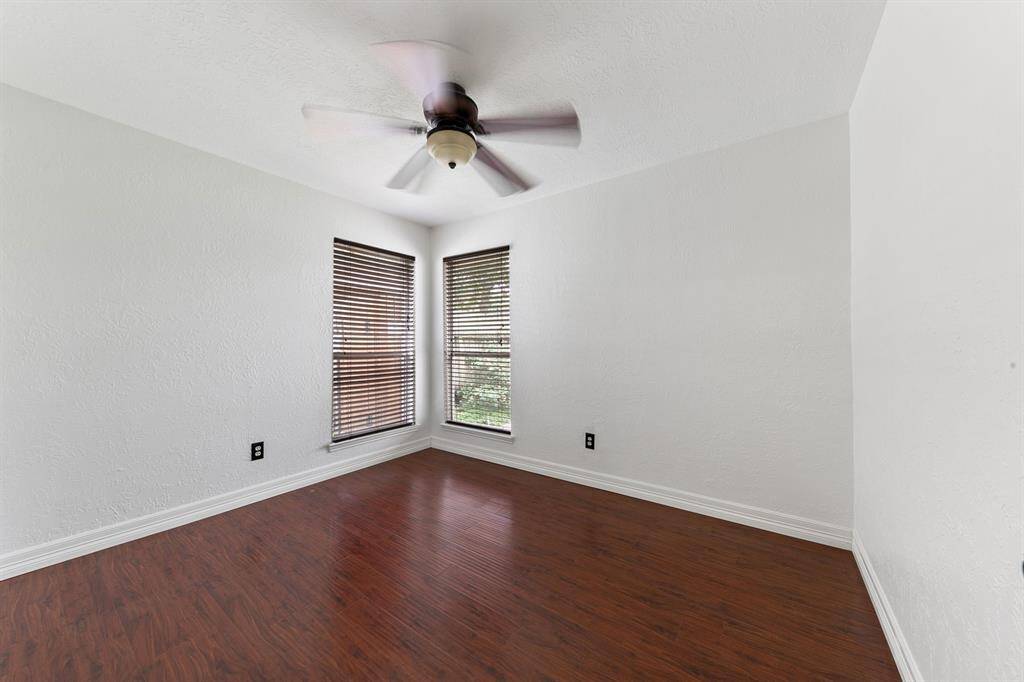 the second of two secondary bedrooms featuring beautiful wood floors and large windows that allow plenty of natural light. Each room offers well-sized closets, providing ample storage space and comfort.