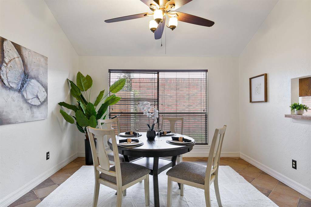 The generously sized dining room boasts a large window that fills the space with natural light, creating an inviting atmosphere. A convenient pass-through to the adjacent kitchen enhances functionality.