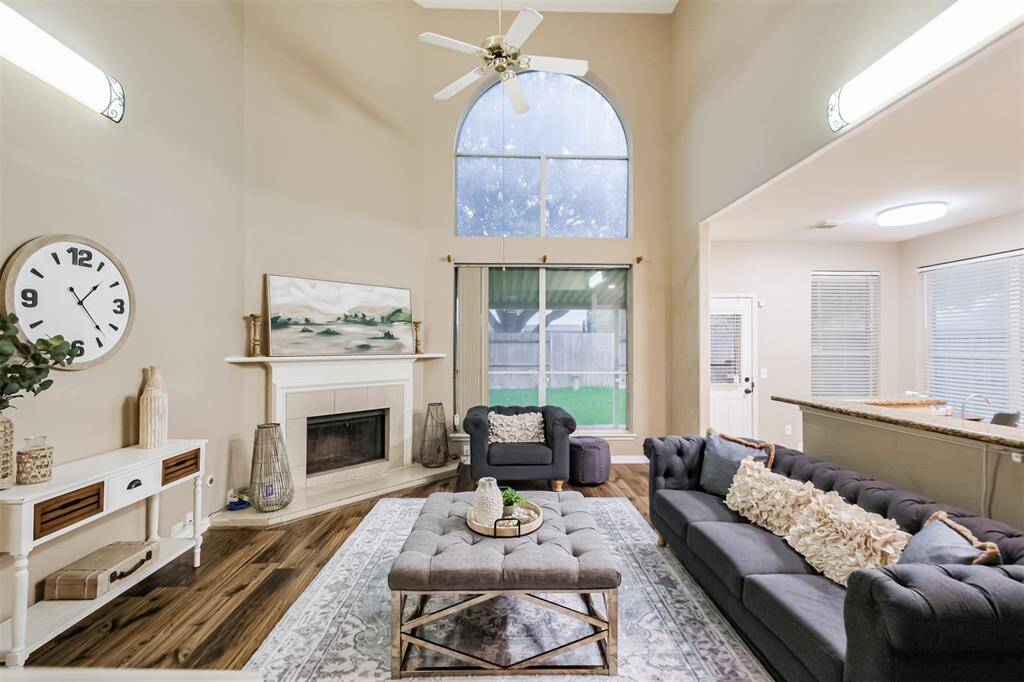 The living room opens up with high ceilings and a corner fireplace.