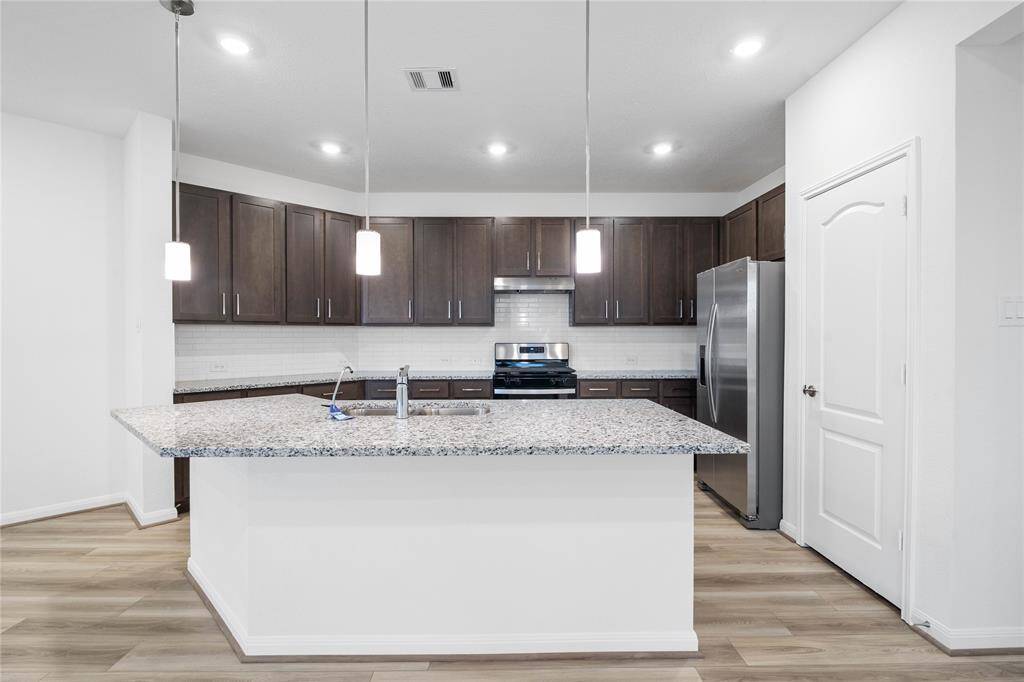 This kitchen is by far any chef’s dream! This spacious kitchen features high ceilings, stained wood cabinets, granite countertops, SS appliances, modern tile backsplash, recessed and pendant lighting, extended counter space, granite kitchen island with double sink and space for breakfast bar, and a walk-in pantry all overlooking your huge family room.