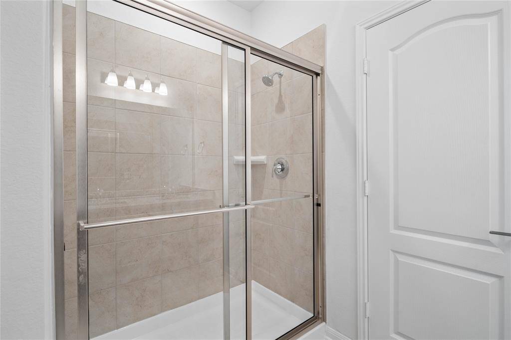Additional view of this primary bathroom features an oversized walk-in shower with tile surround.