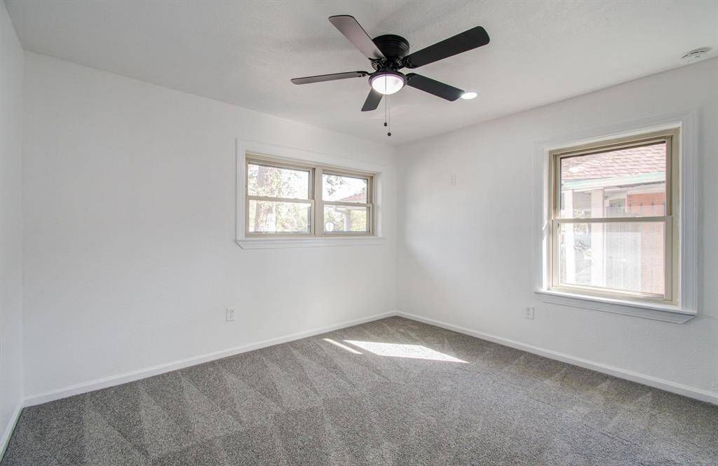 Bright bedroom with generous space, large windows, and a comfortable atmosphere