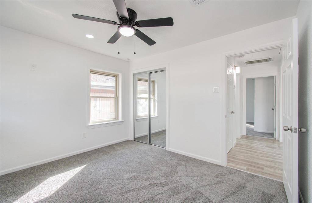 Bright bedroom with generous space, large windows, and a comfortable atmosphere