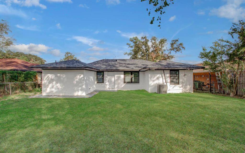 Back view of the property showcasing a well-maintained yard and serene outdoor space.