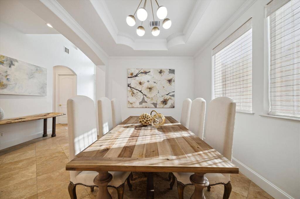 Formal dining room to the left of entry with raised ceiling, upgraded lighting, flooded with light.