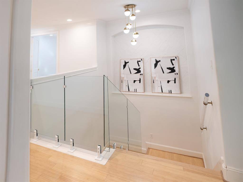 The striking glass panel staircase opens up into the gameroom.