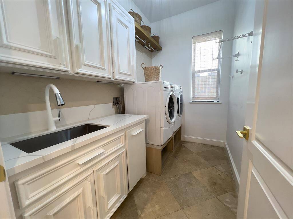 Conveniently located first floor utility room.  Washer and dryer elevated for comfort.  Hanging space, sink and plenty of cabinets for storage.