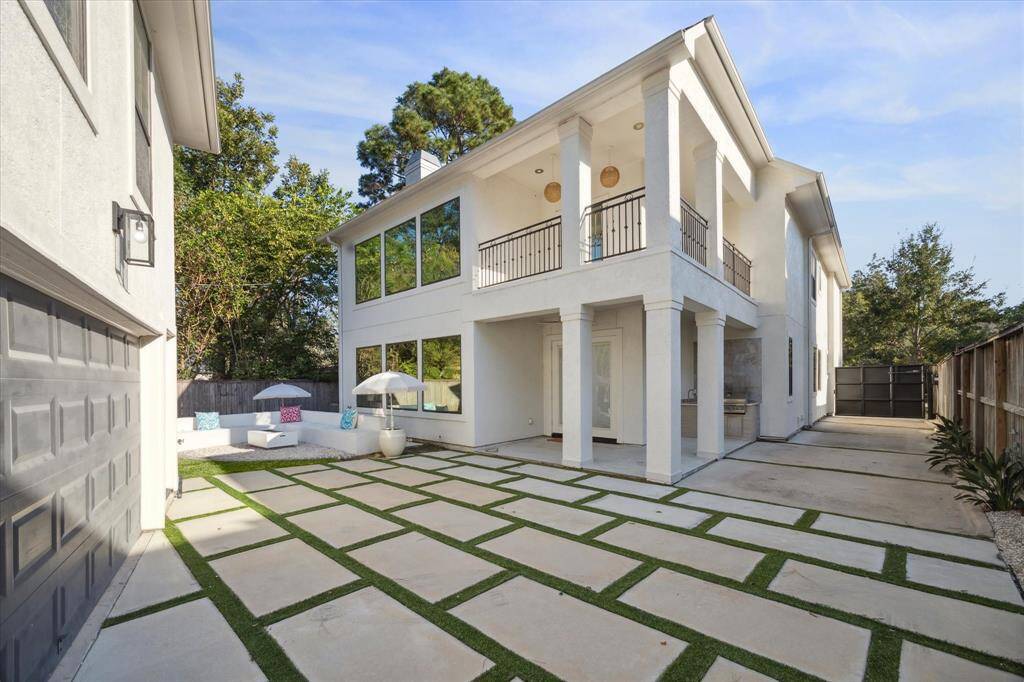 Gated driveway leads to the low maintenance driveway, covered back patio and summer kitchen.
