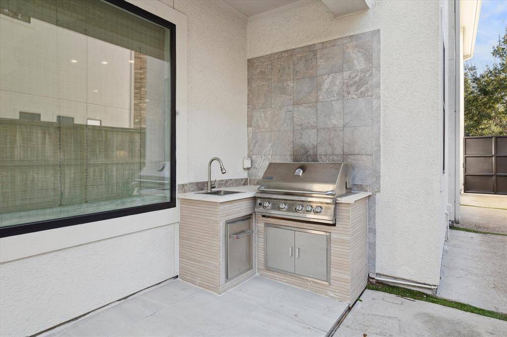 Built in grill and sink located on the covered back porch.  Plenty of storage underneath.