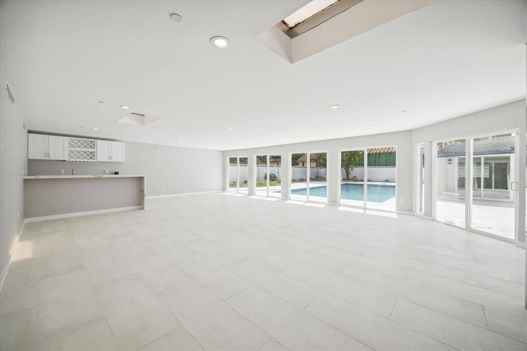 Grand scale entertaining!  Large great room with wet bar and sliding glass windows onto the pool deck.