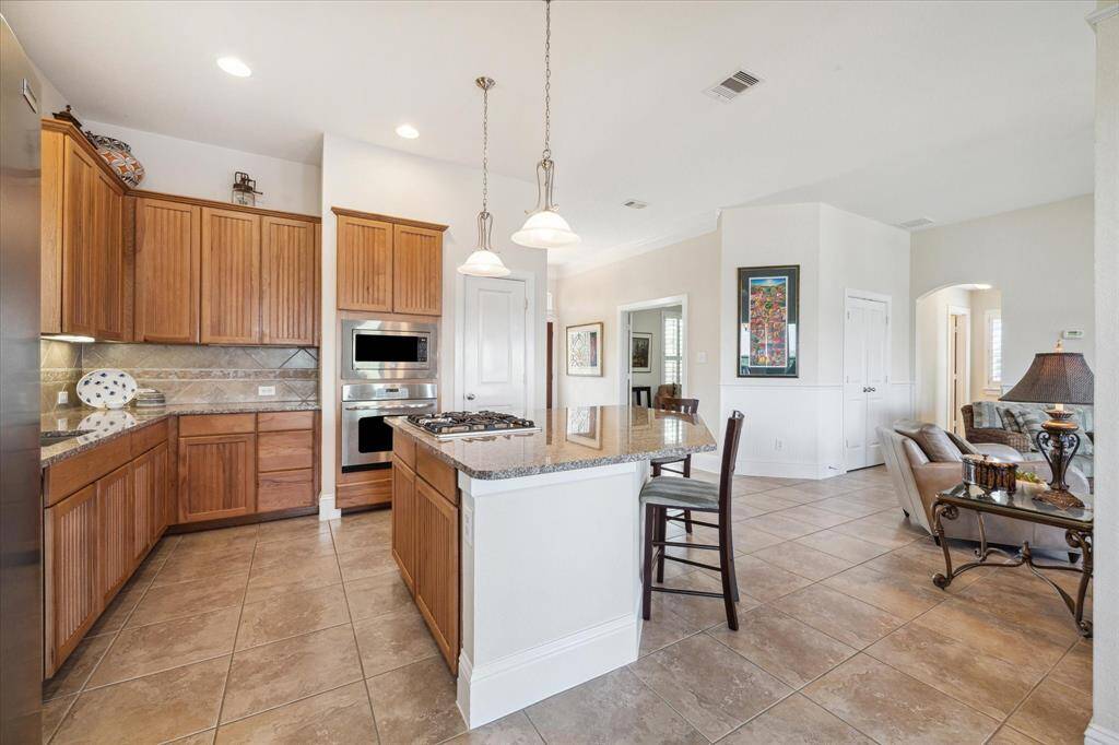 A closer look at the kitchen showcases the seamless flow between the cooking space and the dining area. The double oven, built-in microwave, and gas cooktop are perfectly positioned for efficiency and ease. The kitchen’s ample counter space and storage options ensure that meal prep and entertaining are always a breeze.