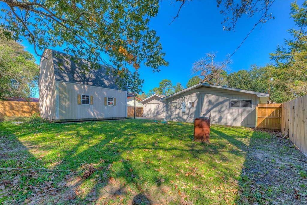 Fenced in backyard with a large 2 story storage building