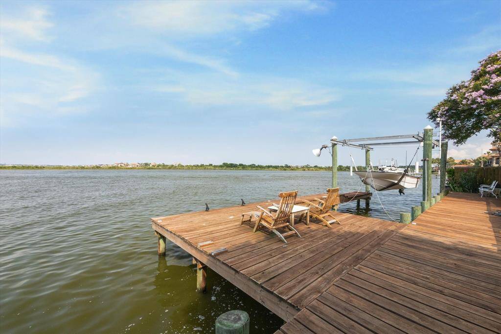 Embrace waterfront living with this private boat dock, offering direct access to the picturesque Nassau Bay Lagoon. The dock is equipped with a boat lift and ample seating, making it a perfect spot to enjoy serene sunsets, fishing, or launching your water adventures. The expansive views create a peaceful retreat right in your backyard.