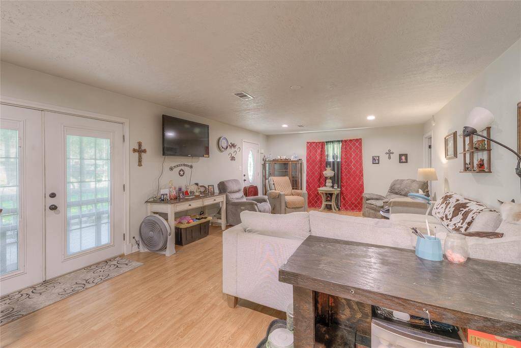The living room with a double front door and windows for natural lighting
