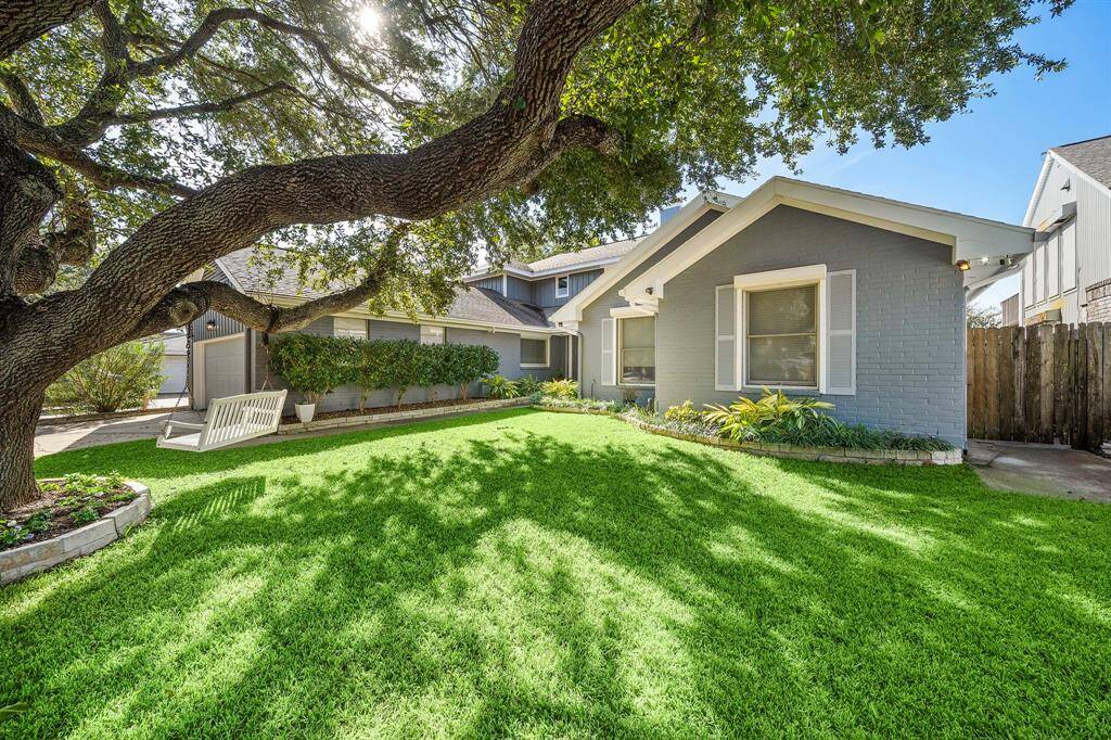Beautifully landscaped front yard well shaded by this large oak tree.