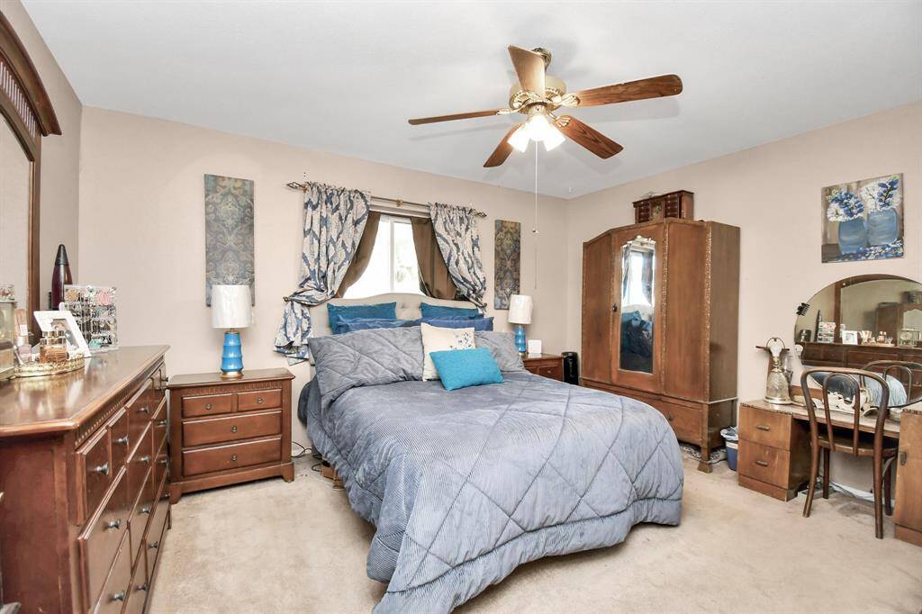 A spacious and comfortable primary bedroom with plenty of closet space and large windows that provide views of the backyard. Neutral tones add to the peaceful ambiance.