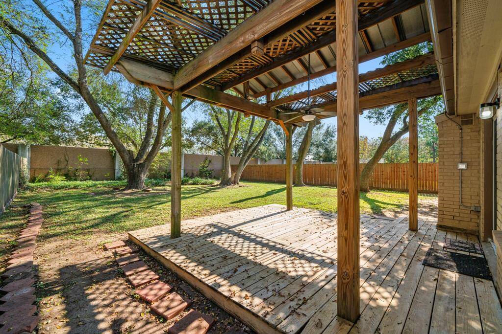 Covered back deck in spacious back yard.