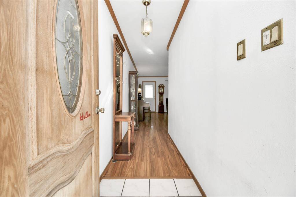 A warm and welcoming view into the hallway from the front door, offering a cozy, intimate atmosphere. While the space is softly lit, it exudes a sense of calm with its neutral tones and classic flooring. The hallway acts as a charming entryway, leading into the heart of the home and setting the tone for the rest of the inviting living spaces.