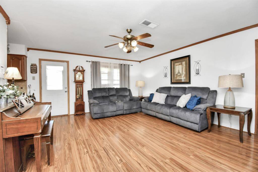 A bright and cozy living room with plenty of space for seating and relaxation. Large windows let in natural light, enhancing the room’s airy feel.