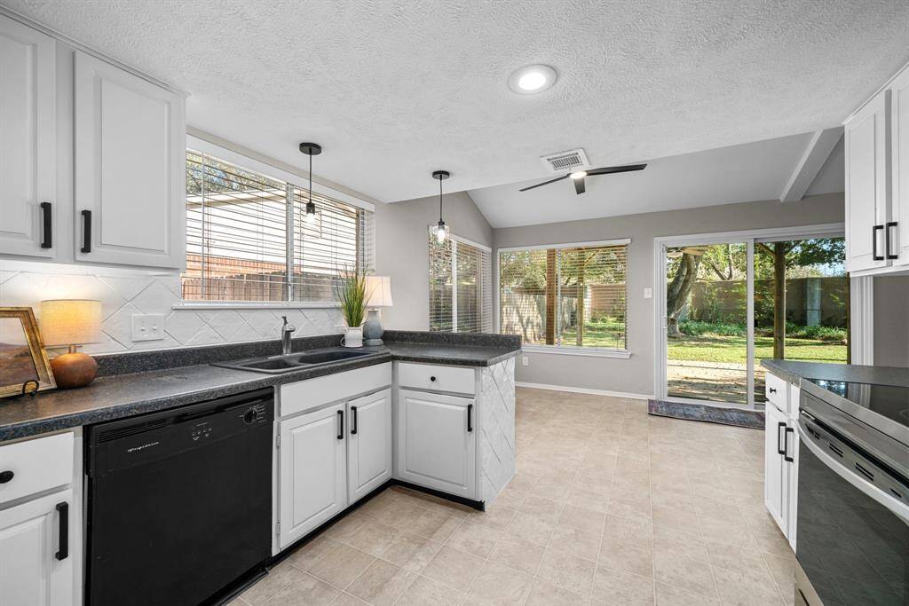 Spacious living room with vaulted ceilings and warm wood laminate flooring.