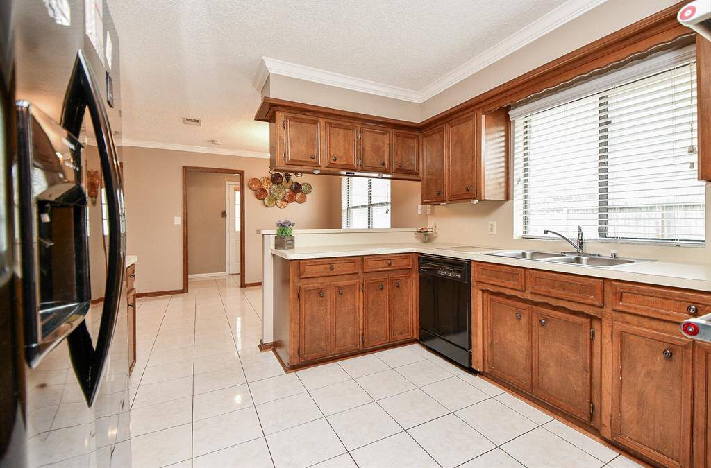 Luxurious kitchen with elegant wood cabinetry and sleek tile flooring.