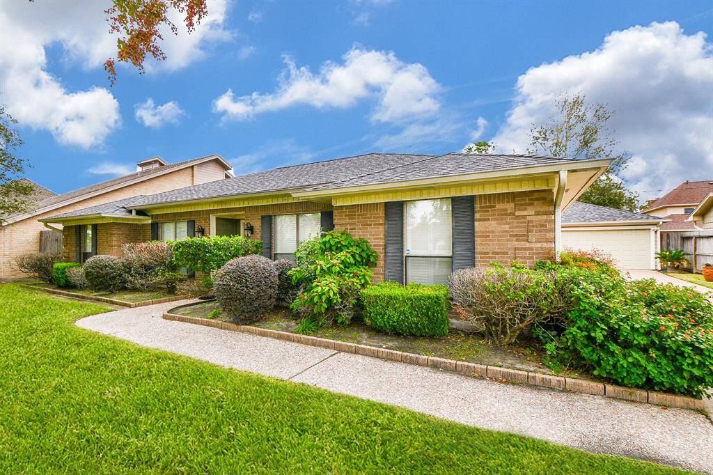 Charming home with a beautifully landscaped front yard and inviting pathway, perfect for welcoming guests.