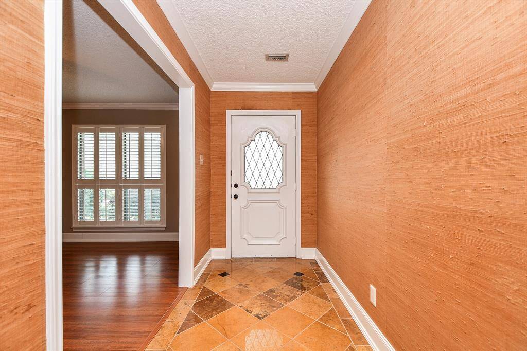 Formal entry w/ accent tile flooring and seagrass style wallpaper