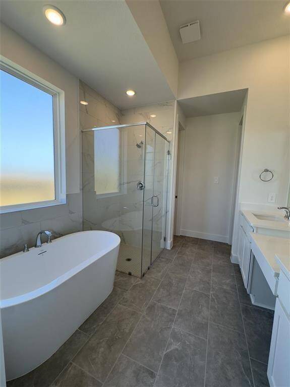 HOME IN PROGRESS - Ensuite primary bathroom with dual vanities, a soaking tub, and a separate walk-in shower for a spa-like retreat!