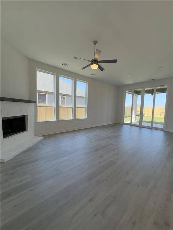 HOME IN PROGRESS - Open-concept family room flows seamlessly into the dining area and kitchen, with a cozy white painted fireplace along with sliding glass doors leading to an extended outdoor patio!