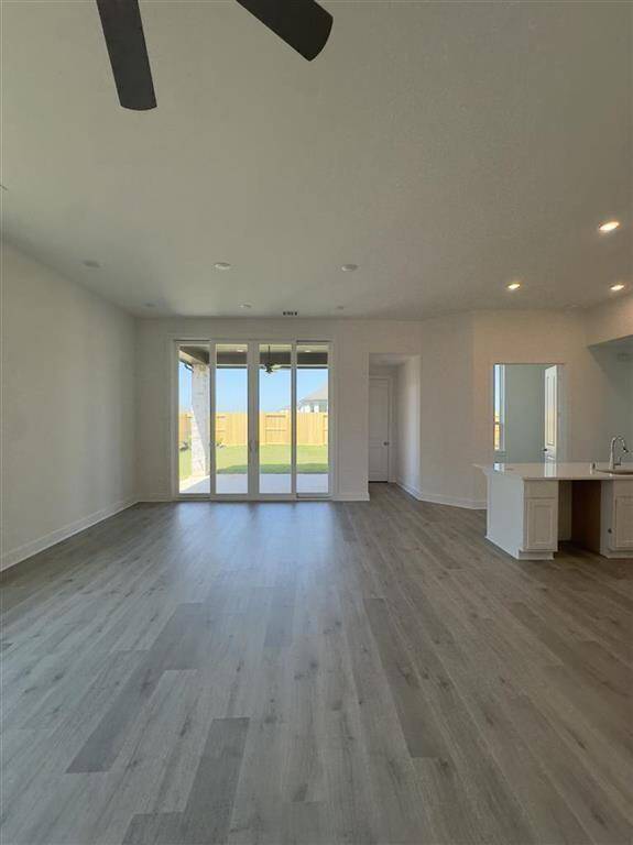 HOME IN PROGRESS - Open-concept family room flows seamlessly into the dining area and kitchen, with a cozy white painted fireplace along with sliding glass doors leading to an extended outdoor patio!
