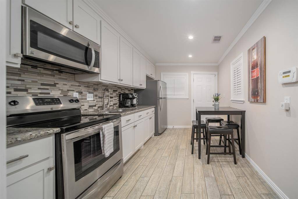 This kitchen is a charmer! Featuring granite countertops, sleek stainless steel appliances, and a decorative tile backsplash, you'll love creating all your favorites here.