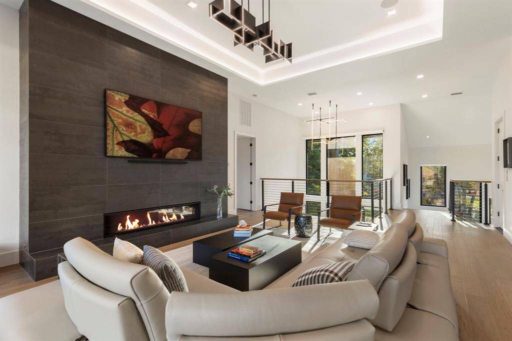 Another view of the living room facing the front vestibule with the fireplace and cove lighting in the ceiling.