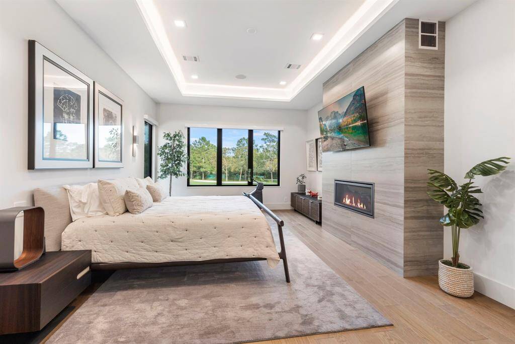 View of the primary bedroom with cove lighting, the fireplace, and views of the golf course.  The 42" heat-n-glow fireplace has vents on the side to disperse heat throughout the bedroom.