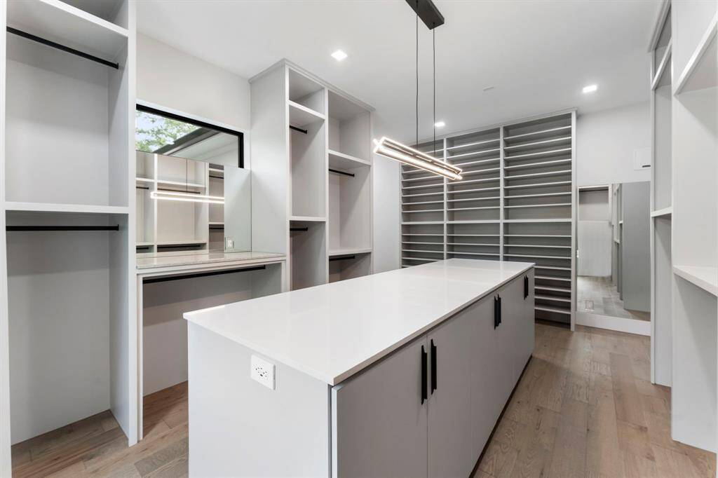 Another view of the primary closet with a wall of shelves for handbags, shoes and adjustable shelves that can accommodate your boot collection.