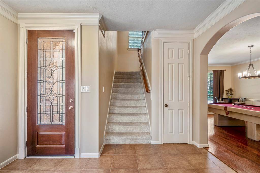 Entryway features crown molding, huge coat closet which could be made into a wine cellar, and an open concept view of the living room, dining room, and staircase.