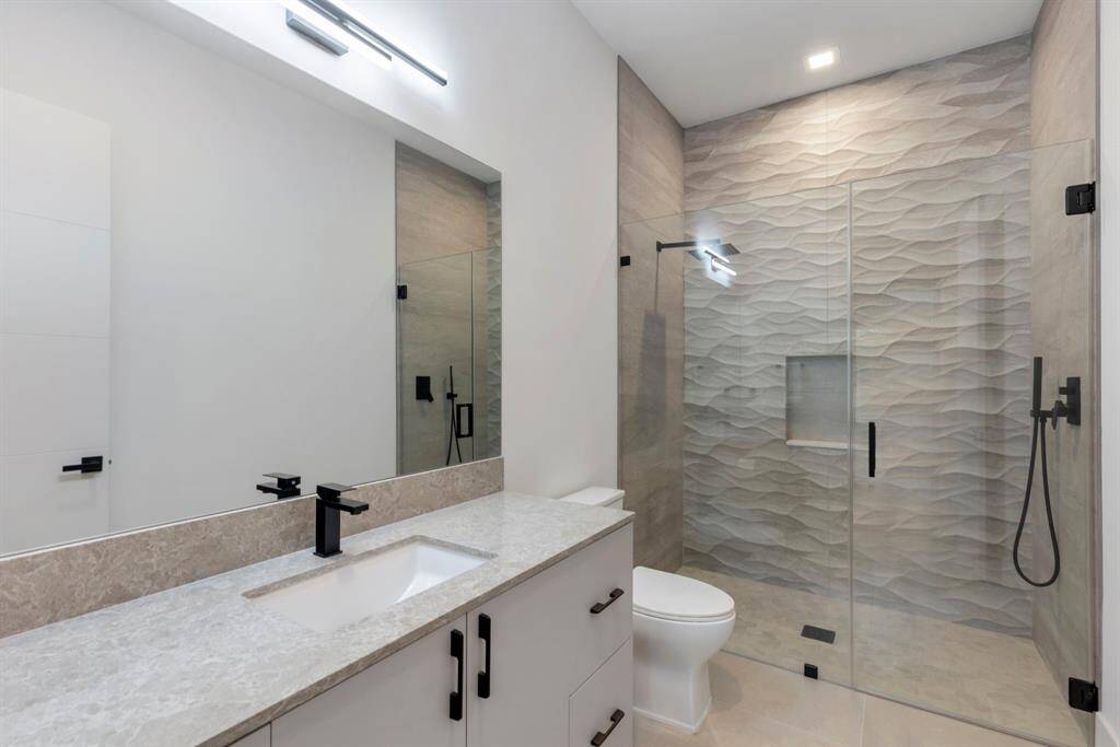 Bedroom 2 bathroom also serves as a pool bath.  It has an oversized countertop, walk in shower with a shampoo niche and linear drain.
