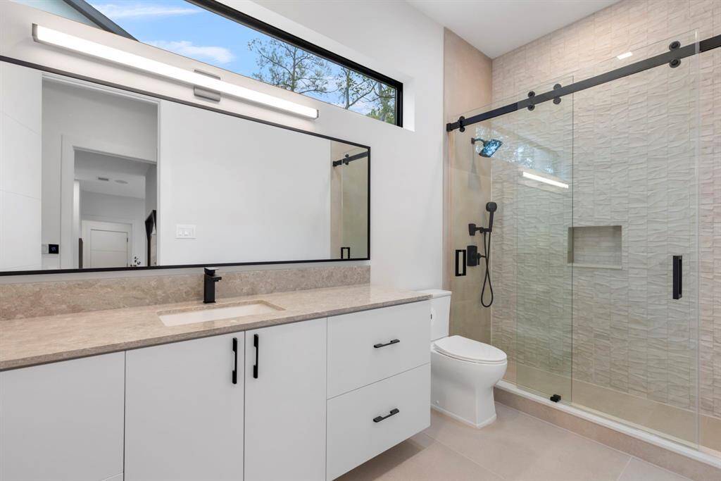 Bedroom 3 bathroom has a walk-in shower and large counter top oversized mirror with an LED light.  The long 96" window allows ample natural lighting.