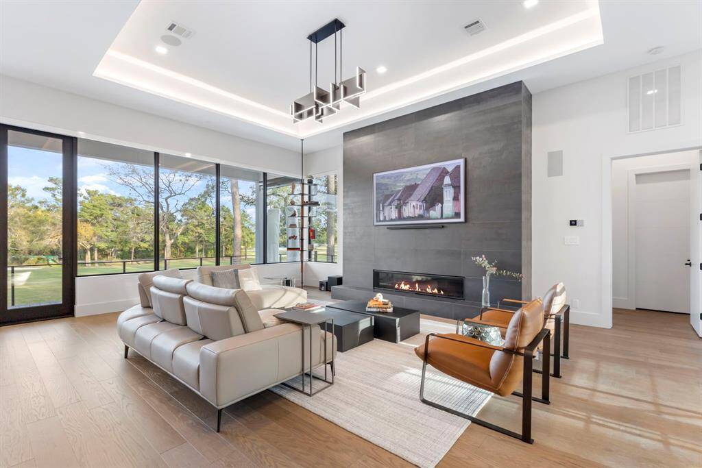 The open-concept living room features large windows with panoramic sunrise views and floor to ceiling tile fireplace accent wall with a 72" contemporary fireplace with a hearth. This made for entertraing layout has neutral tones which create a bright living space with spectacular views. The doorway on the right leads to the ensuite guest/study room, bathroom and private office niche.